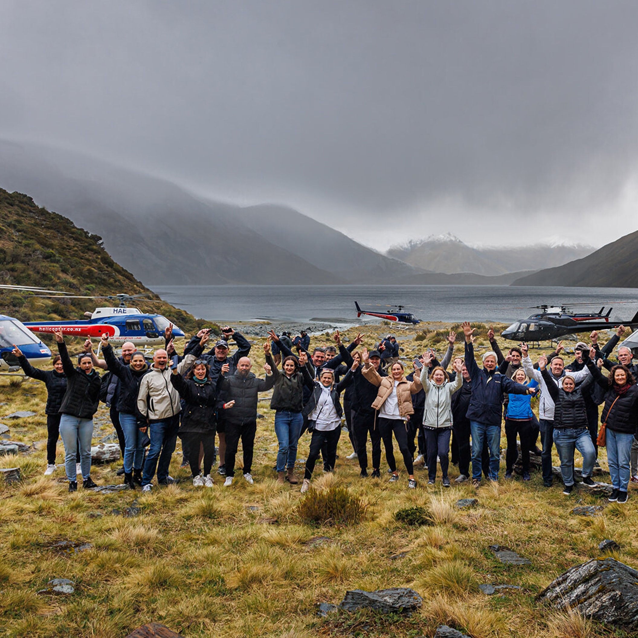 Incentive group waving after landing by mountain lake