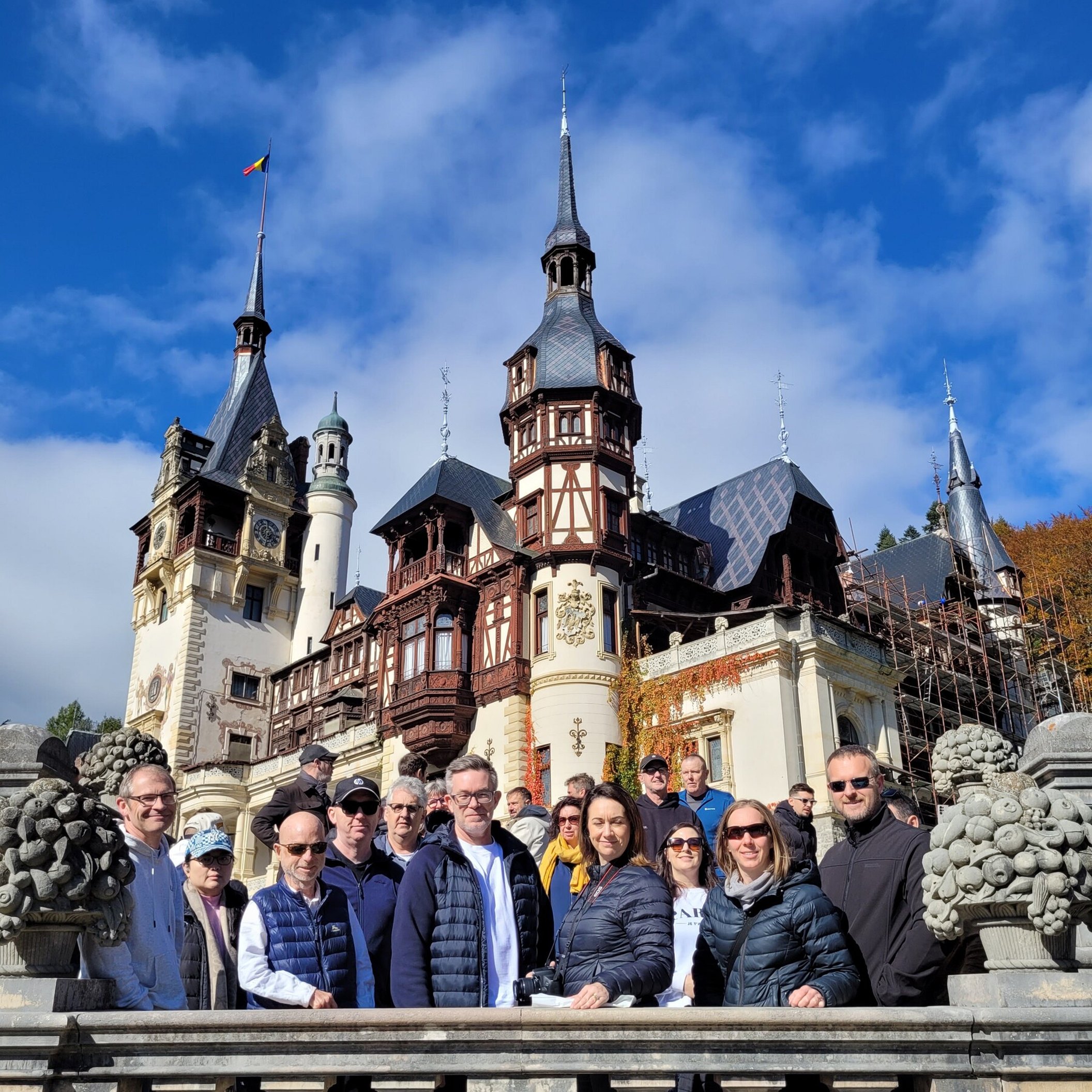 Incentive group posing in front of Peleș Castle in Sinaia, Romania