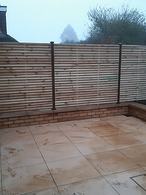 Durapost  Brown Posts with slatted panels. - On this install we fitted the slotted Durapost into core drilled holes on a low retainer wall. Set into place using a fast set concrete. The posts had the Durapost cover strip and post cap fitted.