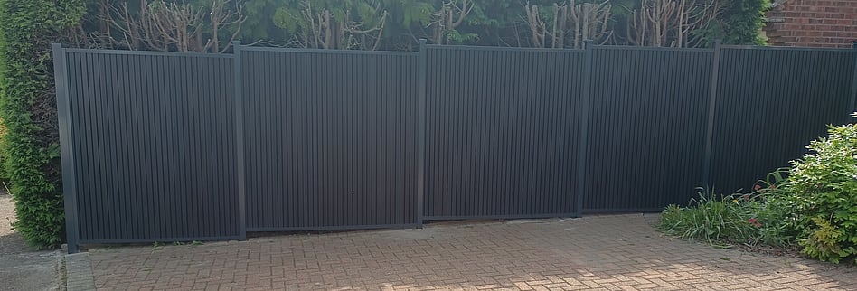 Image shows six Durapost Urban type composite panels installed beside a driveway. Panels are fitted to Durapost classic posts (anthracite colour) fully framed  complete with cover strips and post caps.