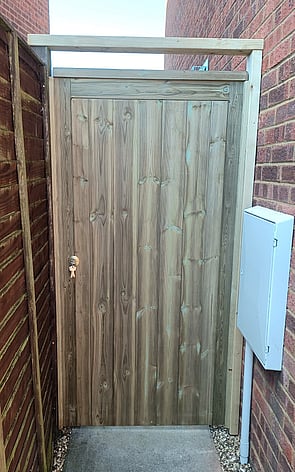 This is a fully framed, ledged and braced gate clad with tongue and grooved timber and treated in green Tanalith wood treatment.  It is fitted to timber wall plates and has a top bar fitted to keep the closing gate post stable.  Fitted with a deadlock.