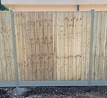 Image shows timber closeboard panel fitted to Durapost classic intermediate posts sitting on a composite gravel board.