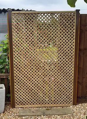 Image shows a a section of Diamond (privacy type) trellis fitted onto brown Durapost (Classic type) posts. Batten has been fitted so that the cover strips and post caps can be installed.
