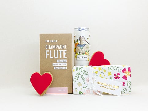 nz designed teatowel, champagne flute and a wine can