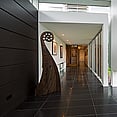 Paunui house, expansive hallway, with dark tiles and Koru statue