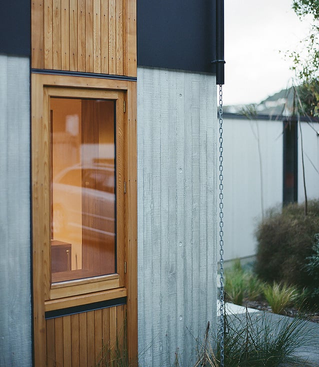 corner of a home showing a wooden window fitted into a concrete in-situ wall.