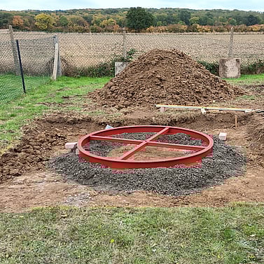 Image shows the new castor ring bedded down on to concrete footings in the excavated base. This has been leveled and is awaiting haunching  up.