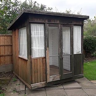 Image shows the old summer house where the owner had started to clean the old exterior wood work which left the walls looking patchy.