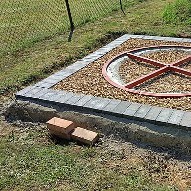 image shows the groundworks complete around the new castor ring. I have set a blue engineering brick edge in place and infilled the ground with gravel to allow drainage.