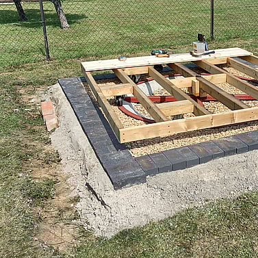 Image shows the timber floor for the summer house being built. 4 x 2 framing with noggins, new castors and then T&G floor boards being fitted. 
