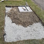 Hardcore has been compacted, first paving slab laid.