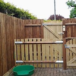 Closeboard fencing, fully clad with a low picket fence adjacent and matching gates