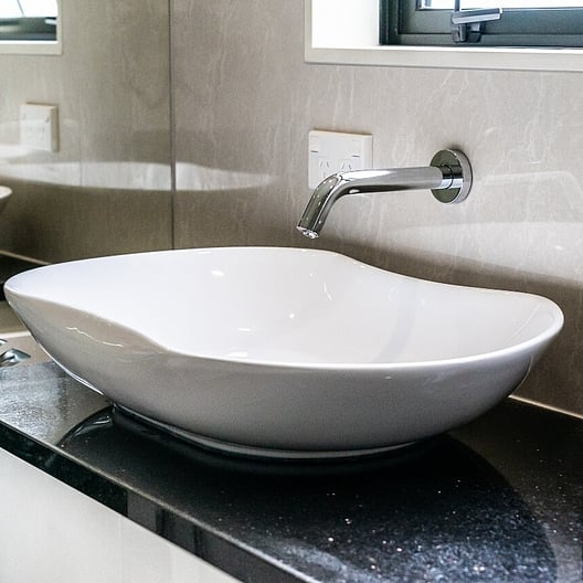 The ET2-20.4 wall mounted sensor tap installed over a ceramic basin in a bathroom setting.