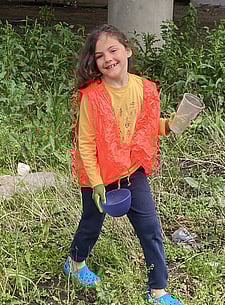 child volunteer picking up bowl during All Rosedale Clean-up 2024