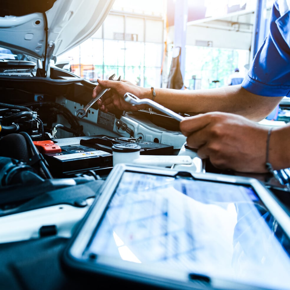 automotive technical support, man working on laptop in automotive workshop