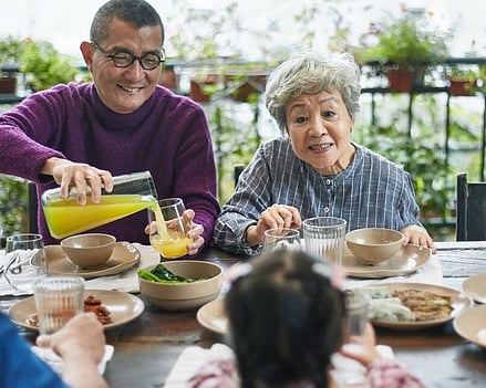 image showing multigenerational family of Asian origin enjoying a meal together