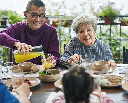 image showing multigenerational family of Asian origin enjoying a meal together