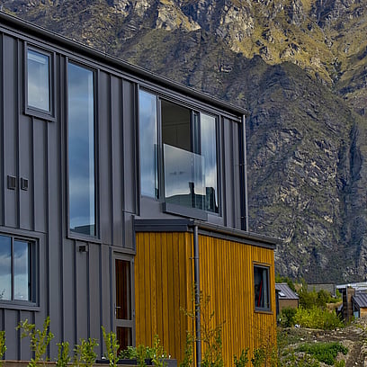 Looking up to the side of the house with the Remarkables Mountain range in the background.