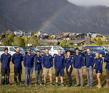 The Fixation Builders team standing together infront of their work vehicles.