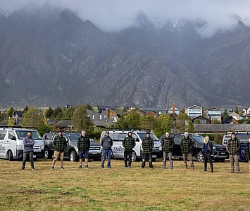 The Fixation Builders team standing together infront of their work vehicles.