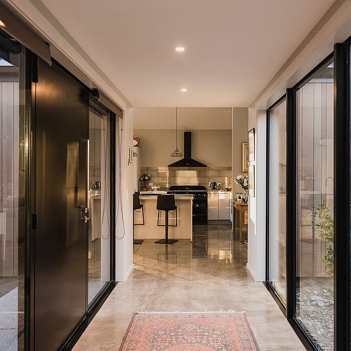 The front entry way with polished concrete floors and large windows framing the front door.