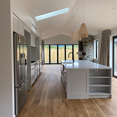 Looking out into the kitchen with large kitchen island, timber floors and skylight allowing lots of natural light in.
