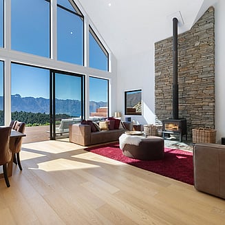 A compact yet clever bathroom with light walls, wood vanity with white top, and timber floors.