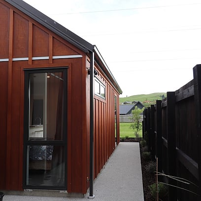 Looking down the side of the home exterior with board and batten cladding.