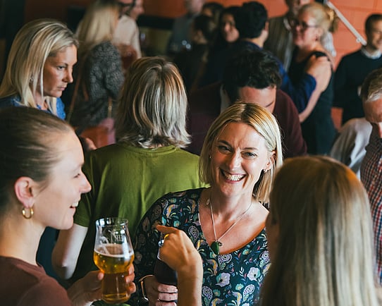 A woman smiling at a Kiwis in Climate social event