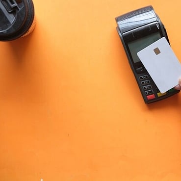A person tapping a card on an EFTPOS machine.