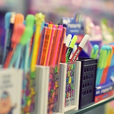 Containers of brightly coloured pens and pencils.