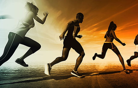 Group of four people running in a line on the beach