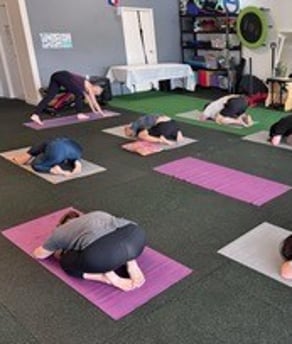 Yoga teacher taking a small class