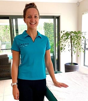 Remedial Massage therapist from Mobile Healing Hands next to massage table