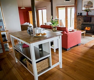 Kitchen island bench set up with coffee and cakes and looking and through to the living area