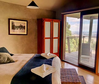 bedroom with a view out to the deck and countryside beyond