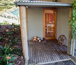 entry door with timber logs stacked outside