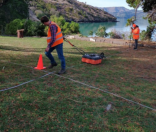 2 scientists using equipment to scan ground