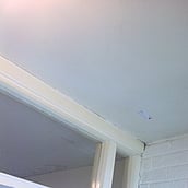 Asbestos insulation board to a ceiling above a main entrance