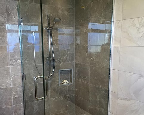Image of a frameless glass shower with tiled walls.
