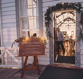An illuminated sign outside the front door of the Kūaotunu Hall announcing the wedding reception being held inside