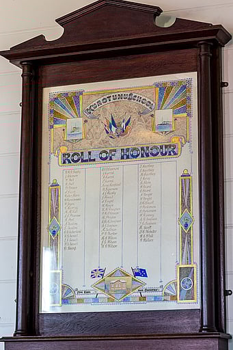 The WW1 Roll of Honour hanging in a wooden frame on the wall of the Kūaotunu Hall