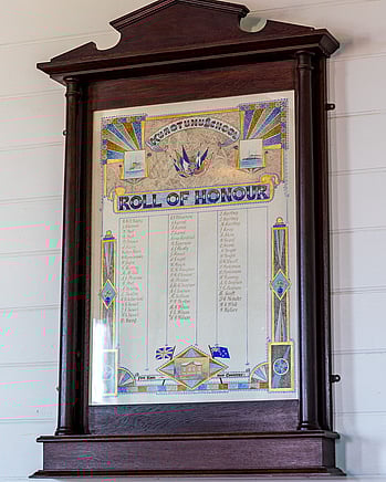 The Kūaotunu WWI Roll of Honour in a wooden frame on the wall of the Kūaotunu hall