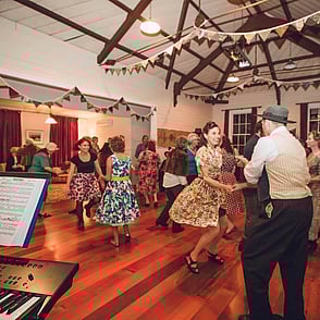 A group of people dancing at a 1940's dance party in the Kūaotunu Hall
