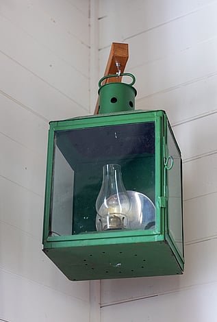 An old ship's lantern hanging in a corner of the Kūaotunu hall
