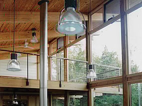 Modern heavy timber post and beam house. Interior view showing south facing window wall with loft level and deck.