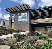 Front yard extension featuring brick, corrugated metal siding, timber screen wall, UPVC windows and bluestone landscaping.