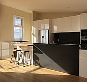 Custom kitchen design featuring two-pac painted panels, honed black and polished Blue Pearl granite, and Tassie Oak butcher block to match the flooring.