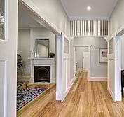 Interior view of bungalow entry with restored fretwork and new timber flooring. The fireplace in the Lounge on the left was completely rebuilt. Stringy Bark solid hardwood flooring was installed throughout.