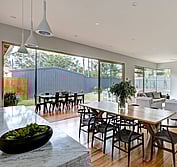 Interior view looking across Carrara marble benchtop to living, dining and veranda. Living Room extension and veranda.